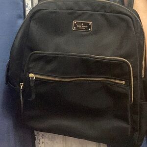 Black Kate Spade used backpack with wear and tear on straps.